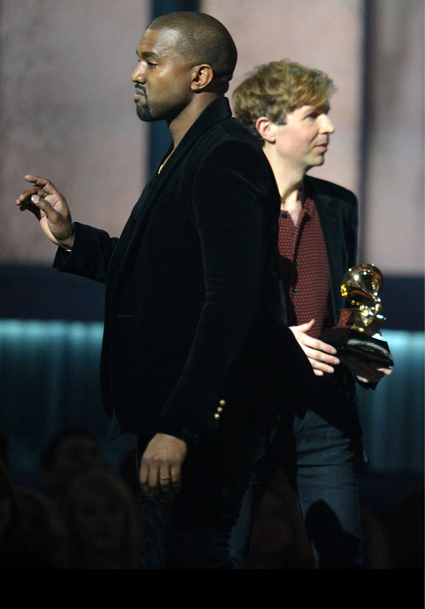 (FILES) In this February 8, 2015 file photo, winner for Album Of The Year Beck reacts as Kanye West appears on stage at the 57th Annual Grammy Awards in Los Angeles February 8, 2015. West on February 11, 2015 urged an overhaul of the Grammys to award commercially successful musicians, even as the rapper toned down his criticism of this year's surprise winner Beck. The famously mercurial West stole the spotlight at the music industry's awards night Sunday when he rushed toward the stage as Beck -- the innovative rocker who has enjoyed critical acclaim, if a niche following, for two decades --accepted the Album of the Year award for his lush, melancholy  Morning Phase.  Soon after the broadcast, West said that Beck should  respect artistry  and give his award to superstar Beyonce for her self-titled album, one of her most intense works which features the ode to marital bliss  Drunk In Love  sung with husband Jay-Z.  AFP PHOTO / ROBYN BECK / FILES